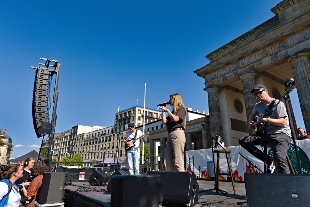 Eine Gruppe von Menschen, die auf einer Bühne vor dem Brandenburger Tor in Berlin, Deutschland, Musik machen.