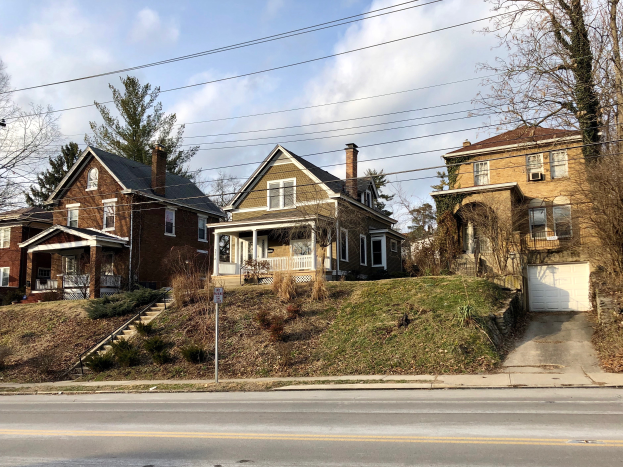 Eine Reihe von Häusern mit verschiedenen architektonischen Merkmalen und Grünflächen unter einem bewölkten Himmel, eines der 10 teuersten Häuser zum Verkauf in Detroit, Michigan.