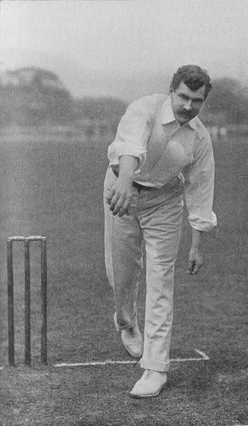 Ein Mann in einem weißen Hemd und Hosen spielt Cricket mit Wickets auf dem Boden, Bäumen und Himmel im Hintergrund, mit dem Text "Cricket-Spieler des Jahres" unten.