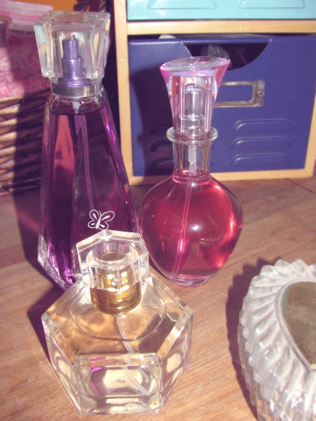 Parfümflaschen und eine Schachtel auf einer Oberfläche angeordnet.