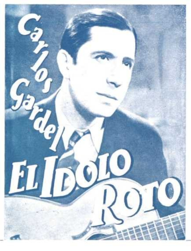 Ein Plakat von El Idolo Roro, einem spanischen S├Ąnger und Songwriter, der eine Gitarre h├Ąlt, ein wei├čes Hemd und einen schwarzen Anzug tr├Ągt, mit zurückgek├Ąmmtem Haar und einem ernsten Ausdruck, vor einem hellblauen Hintergrund mit fetter schwarzer Schrift.