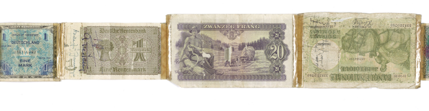 Ein altes Buch mit einem Stapel verschiedener Scheine alter deutscher Banknoten darauf.