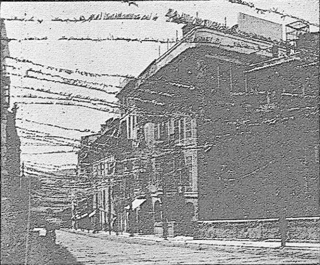 Schwarz-weiß-Foto eines Gebäudes mit Stacheldraht oben, beschriftet mit "New York Post Office, New York City", auf einer Straße mit einem Himmel-Hintergrund.