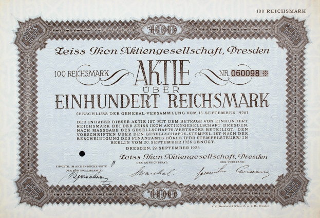 Alter deutscher Aktienchein für 100 Reichsmark mit schwarzem Rand und deutschem Text.