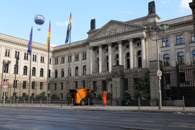 Großer moderner Bau mit zahlreichen Fenstern, als Bundestag in Berlin, Deutschland identifiziert, umgeben von Straßeninfrastruktur, Passanten und Fahrzeugen.