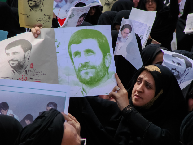 Eine Gruppe iranischer Frauen in schwarzer Kleidung, einige mit Brille, halten Bilder des Präsidenten Mahmoud Ahmadinejad während einer Kundgebung in Tehran hoch.