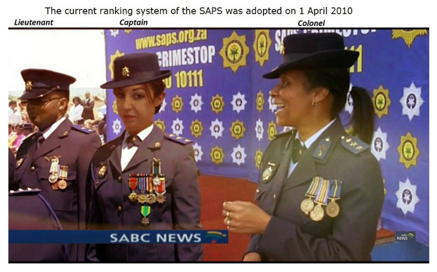 Gruppe von Menschen in Uniformen und Hüten, die vor einer Fahne mit dem Text "Das aktuelle Rankingsystem der SAP wurde am 1. April 2010 eingeführt" stehen.