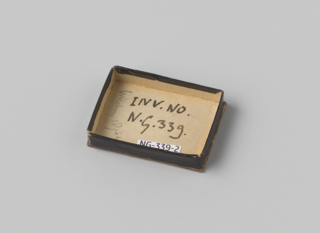 Kleiner schwarzer Kasten mit weißer Beschriftung auf weißer Oberfläche, Beschriftung enthält Text.